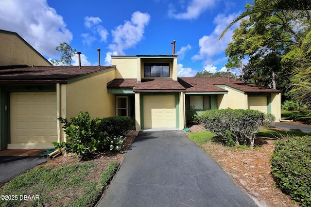 219 Club House Blvd Unit 219, New Smyrna Beach, FL 32168 - view of front of house featuring stucco siding, a shingled roof, and asphalt driveway