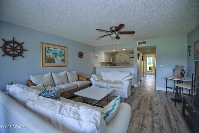 219 Club House Blvd Unit 219, New Smyrna Beach, FL 32168 - living room featuring a ceiling fan, a textured ceiling, and dark wood-type flooring