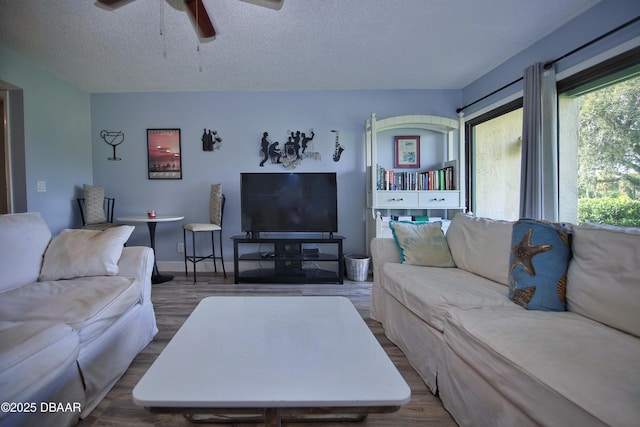 219 Club House Blvd Unit 219, New Smyrna Beach, FL 32168 - living room featuring ceiling fan, dark wood-type flooring, and a textured ceiling