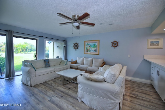 219 Club House Blvd Unit 219, New Smyrna Beach, FL 32168 - living area featuring a textured ceiling, wood finished floors, baseboards, and a ceiling fan