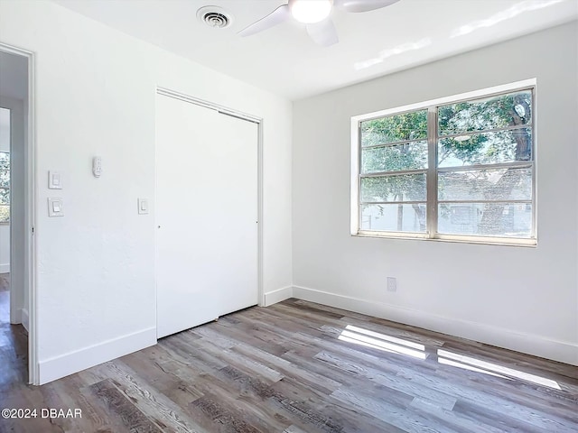 unfurnished bedroom featuring light wood-type flooring, ceiling fan, and a closet