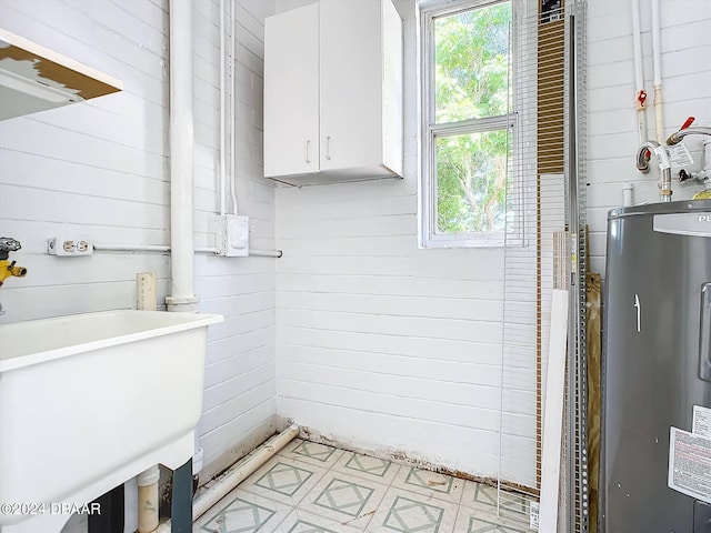 bathroom with wood walls and water heater