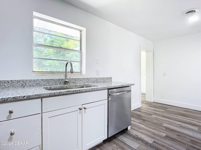 kitchen featuring white cabinetry, sink, light stone countertops, stainless steel dishwasher, and dark wood-type flooring