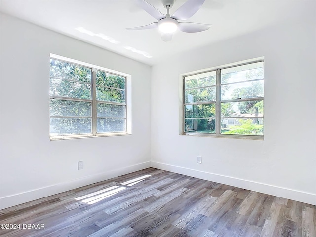 unfurnished room featuring hardwood / wood-style floors, ceiling fan, and plenty of natural light