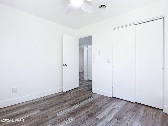 unfurnished bedroom with a closet, hardwood / wood-style floors, and ceiling fan