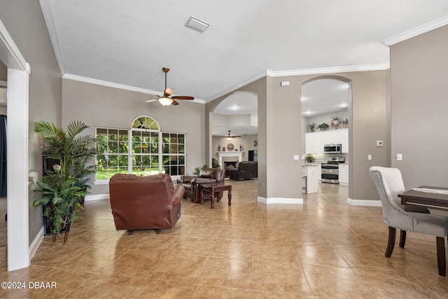 tiled living room featuring ceiling fan, a textured ceiling, and crown molding