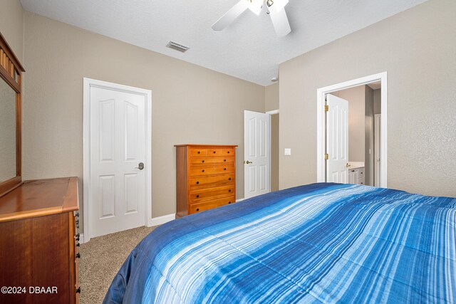 carpeted bedroom featuring a textured ceiling, ceiling fan, and ensuite bathroom