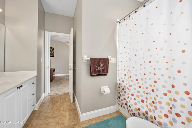 bathroom with walk in shower, tile patterned flooring, a textured ceiling, vanity, and toilet