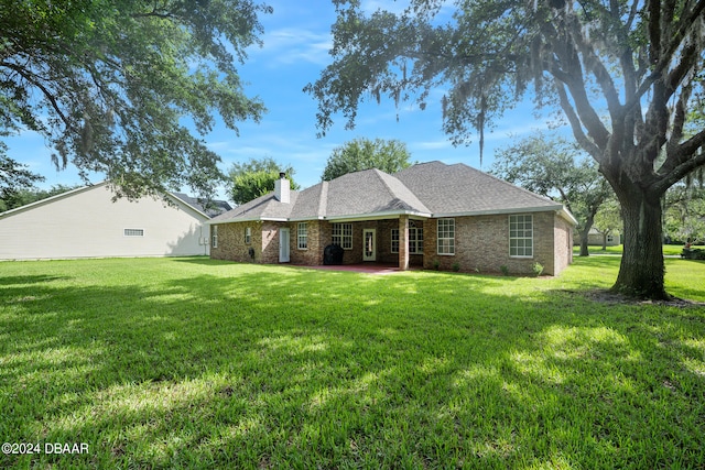 rear view of property featuring a yard