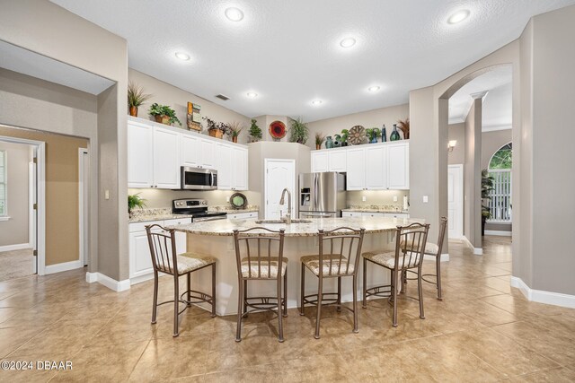 kitchen with white cabinetry, sink, a kitchen island with sink, and appliances with stainless steel finishes