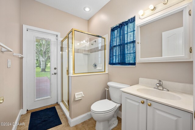 bathroom featuring vanity, tile patterned floors, toilet, and a shower with door