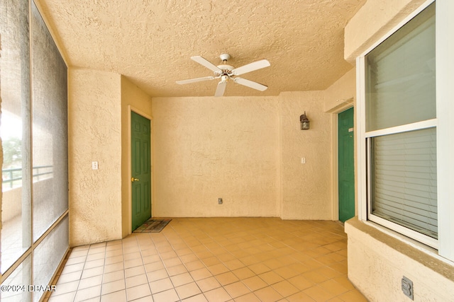 unfurnished room with light tile patterned floors, a textured ceiling, and ceiling fan