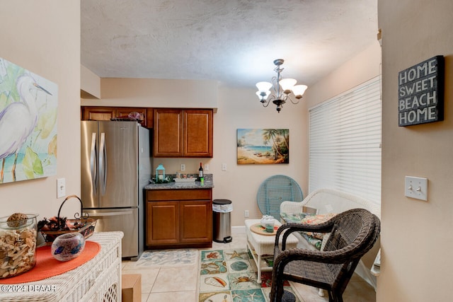 kitchen with stainless steel refrigerator, hanging light fixtures, a chandelier, a textured ceiling, and light tile patterned flooring