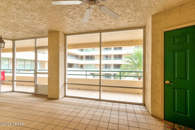 unfurnished sunroom with ceiling fan