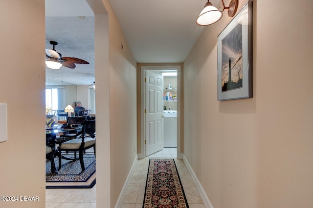 corridor with light tile patterned floors and washer / clothes dryer