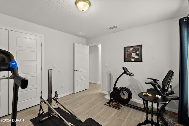 workout room featuring a textured ceiling