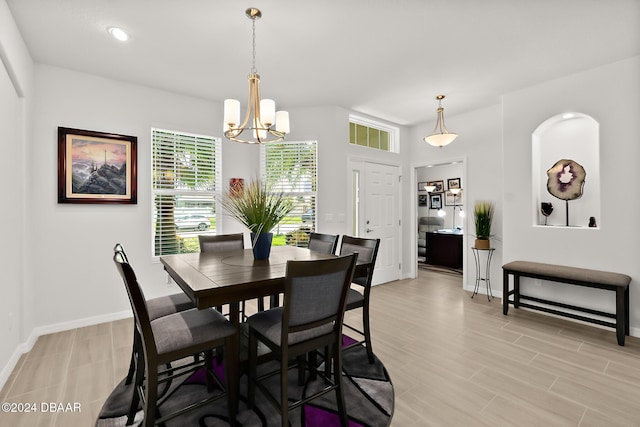 dining space featuring a notable chandelier and light wood-type flooring