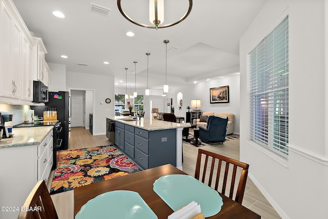 dining space with light wood-type flooring, a wealth of natural light, and sink