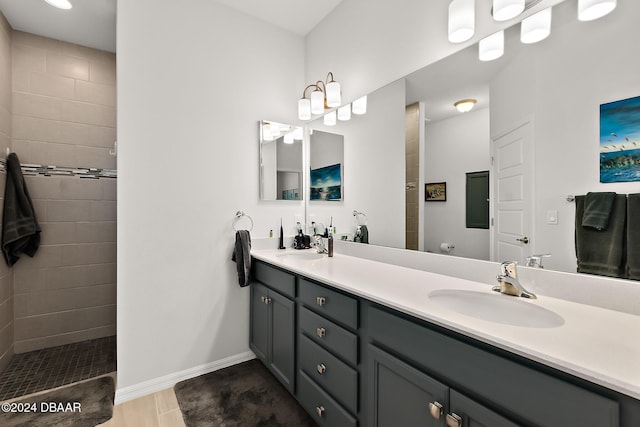 bathroom with tile patterned floors, vanity, and tiled shower