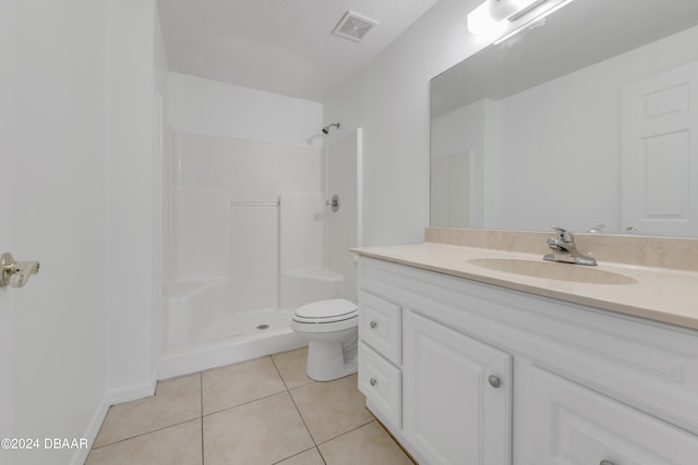 bathroom with a shower, tile patterned floors, toilet, and vanity