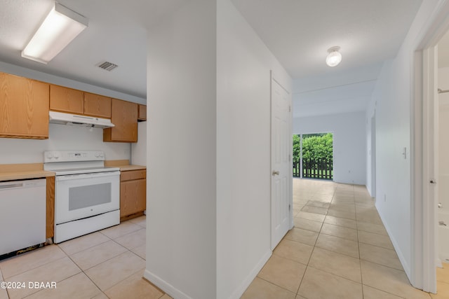 kitchen with white appliances and light tile patterned floors