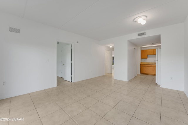 empty room with light tile patterned floors and sink