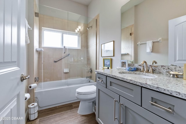 full bathroom with vanity, hardwood / wood-style flooring, shower / bath combination with glass door, and toilet