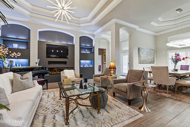 living room with ornamental molding, a healthy amount of sunlight, and built in features