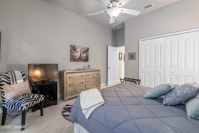 carpeted bedroom with ceiling fan, vaulted ceiling, and a closet