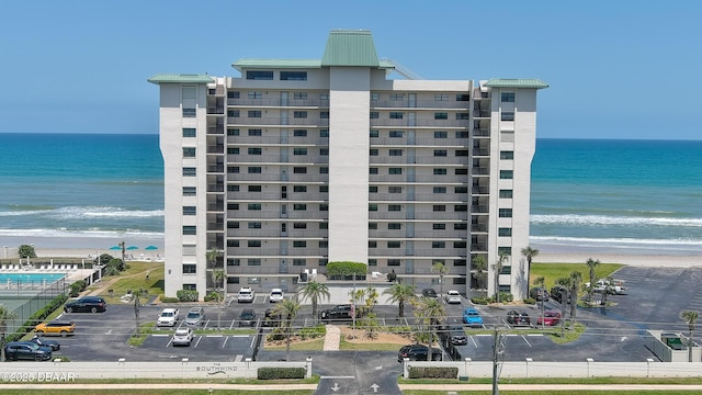5499 S Atlantic Ave Unit 104, New Smyrna Beach, FL 32169 - view of building exterior featuring a water view, a beach view, and uncovered parking