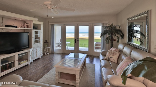 5499 S Atlantic Ave Unit 104, New Smyrna Beach, FL 32169 - living room featuring dark wood finished floors, french doors, ceiling fan, and a textured ceiling