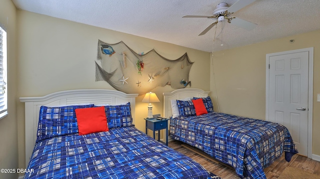 5499 S Atlantic Ave Unit 104, New Smyrna Beach, FL 32169 - bedroom with ceiling fan, a textured ceiling, and wood finished floors
