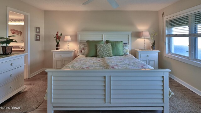 5499 S Atlantic Ave Unit 104, New Smyrna Beach, FL 32169 - bedroom with dark wood-style flooring, baseboards, and a ceiling fan