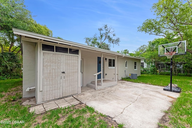 182 Grove St, Ormond Beach, FL 32174 - back of house featuring central AC, a lawn, and a patio