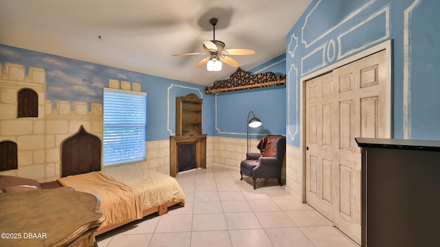 1929 Spruce Creek Lndg, Port Orange, FL 32128 - bedroom featuring lofted ceiling, a wainscoted wall, light tile patterned floors, a ceiling fan, and a closet