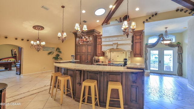 1929 Spruce Creek Lndg, Port Orange, FL 32128 - kitchen featuring a chandelier, high vaulted ceiling, light tile patterned floors, french doors, and a kitchen bar