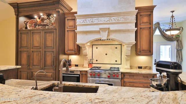 1929 Spruce Creek Lndg, Port Orange, FL 32128 - kitchen featuring premium range, light stone countertops, brown cabinetry, and a desk