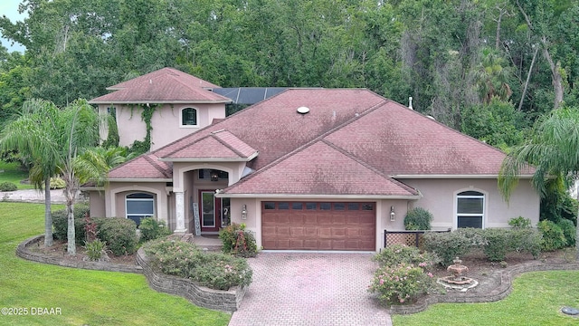 1929 Spruce Creek Lndg, Port Orange, FL 32128 - mediterranean / spanish-style house featuring stucco siding, a garage, a front yard, and driveway
