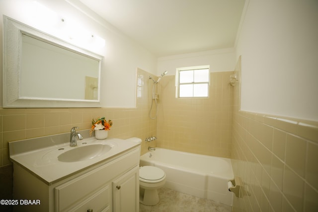 full bathroom featuring toilet, vanity, washtub / shower combination, and tile walls