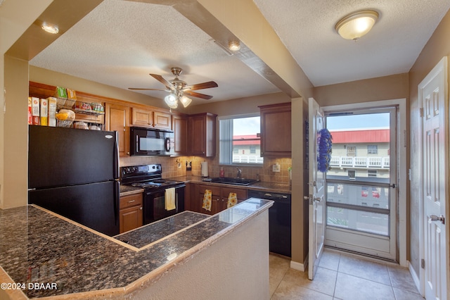 kitchen featuring sink, backsplash, kitchen peninsula, a textured ceiling, and black appliances