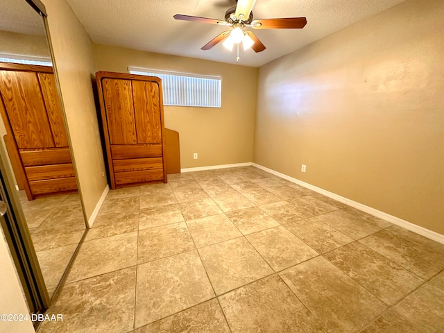 spare room featuring ceiling fan and a textured ceiling