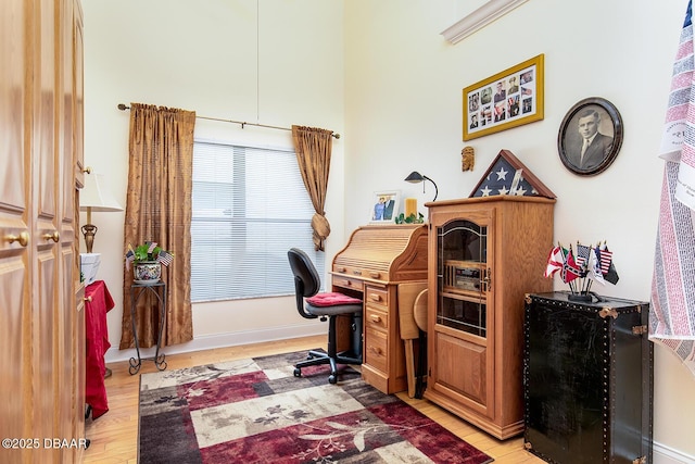 home office with baseboards and light wood-style flooring