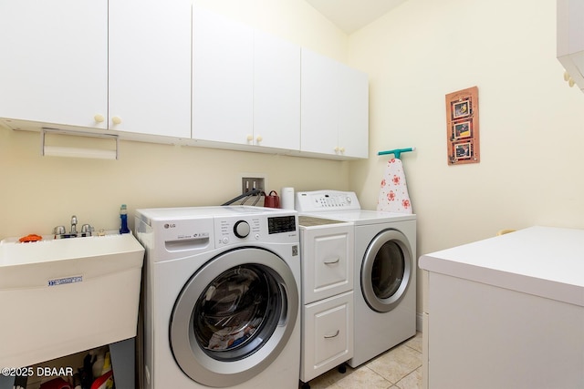 laundry area featuring washing machine and dryer, light tile patterned floors, cabinet space, and a sink