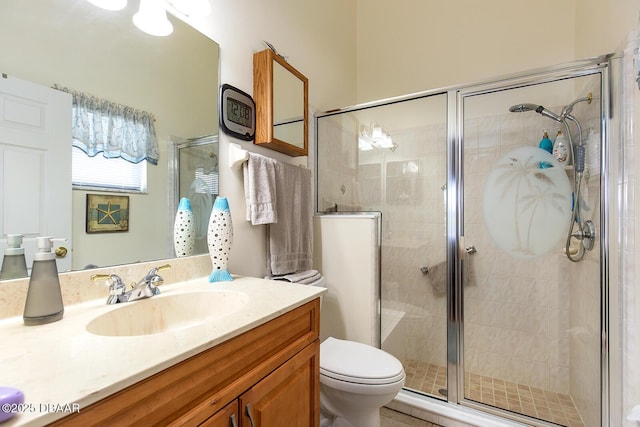 bathroom featuring toilet, a stall shower, and vanity