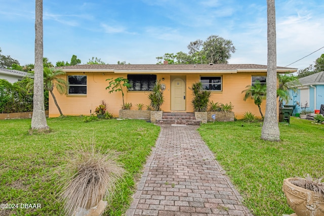 ranch-style home featuring a front lawn