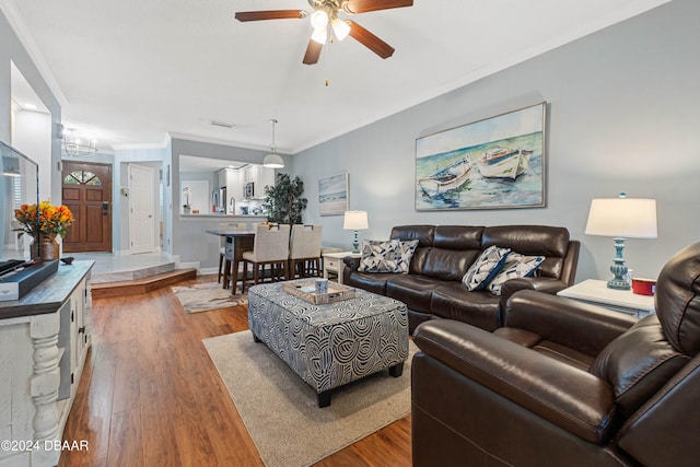 living room with ceiling fan, wood-type flooring, and ornamental molding