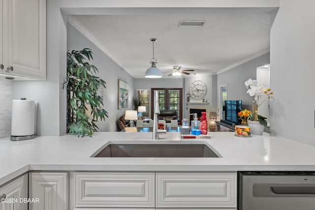 kitchen featuring white cabinets, sink, crown molding, ceiling fan, and a textured ceiling