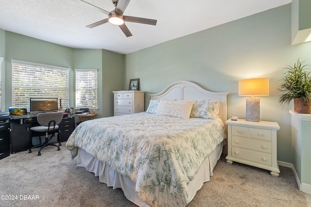 carpeted bedroom with ceiling fan and a textured ceiling