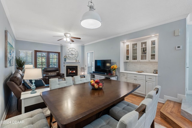 dining room featuring crown molding, light hardwood / wood-style flooring, and ceiling fan