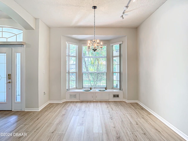 46 Coquina Point Dr, Ormond Beach, FL 32174 - entrance foyer featuring light wood-type flooring, plenty of natural light, a textured ceiling, and an inviting chandelier
